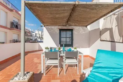 a patio with a table and chairs on a roof at Vistamar 2: Primera línea de mar con gran terraza in Sitges