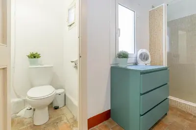 a bathroom with a toilet and a blue cabinet at Vistamar 2: Primera línea de mar con gran terraza in Sitges