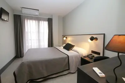 a hotel room with a bed and a desk at Hotel Esplugues in Esplugues de Llobregat