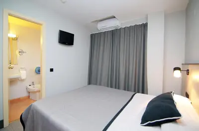 a hotel room with a bed and a bathroom at Hotel Esplugues in Esplugues de Llobregat