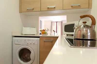 a kitchen with a washing machine and a microwave at MH Apartments Liceo in Barcelona