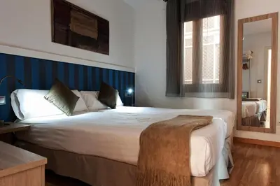 a bedroom with a large bed and a mirror at MH Apartments Liceo in Barcelona