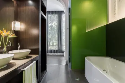 a green bathroom with a tub and a sink at Room Mate Carla, Barcelona in Barcelona