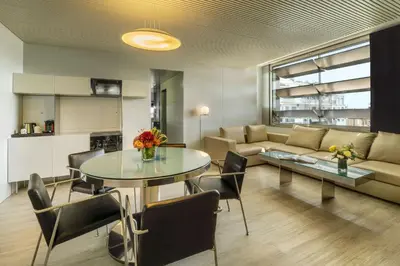 a living room with a table and a couch at NH Collection Barcelona Constanza in Barcelona