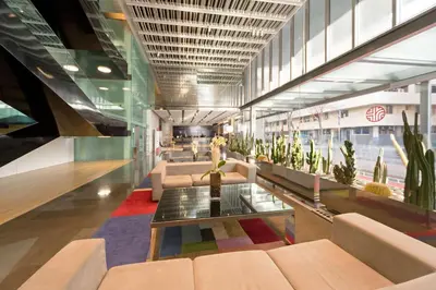a lobby with couches and plants in a building at NH Collection Barcelona Constanza in Barcelona