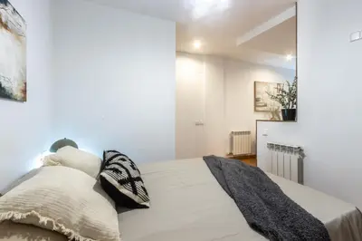 a bedroom with a bed with white walls at Fantástico loft cerca centro by Lofties in Terrassa