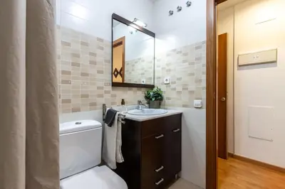 a bathroom with a toilet and a sink and a mirror at Fantástico loft cerca centro by Lofties in Terrassa