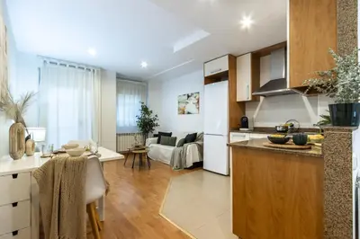a kitchen and a living room with a table at Fantástico loft cerca centro by Lofties in Terrassa