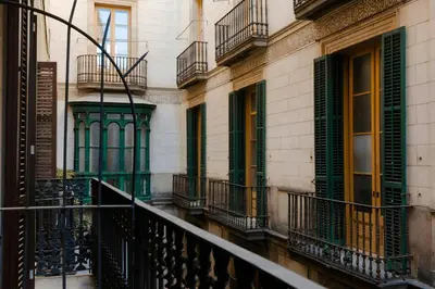 a balcony of a building with green doors and windows at Hotel Hamsa House in Barcelona