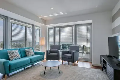a living room with a blue couch and two chairs at Alcam Llum Deluxe in Barcelona