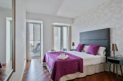 a bedroom with a large bed with purple pillows at Alcam Llum Deluxe in Barcelona