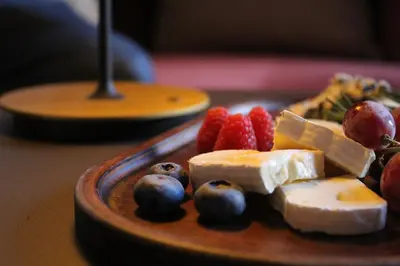 a plate of cheese and fruit on a table at Hotel Medinaceli 4 Estrellas SUPERIOR in Barcelona