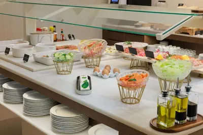 a buffet with bowls of food on a table at Hotel Medinaceli 4 Estrellas SUPERIOR in Barcelona