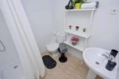 a white bathroom with a toilet and a sink at Barcelona City North Hostal in Barcelona