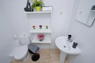 a white bathroom with a toilet and a sink at Barcelona City North Hostal in Barcelona