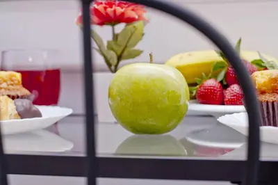 a plate of food with a green apple and strawberries at Barcelona City North Hostal in Barcelona