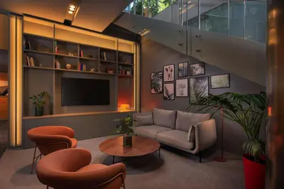 a living room with a couch and a tv at Four Points by Sheraton Barcelona Diagonal in Barcelona