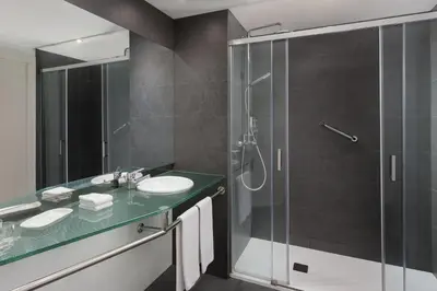 a bathroom with a glass shower and a sink at Four Points by Sheraton Barcelona Diagonal in Barcelona