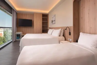 two beds in a hotel room with a tv at Four Points by Sheraton Barcelona Diagonal in Barcelona