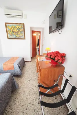 a living room with a couch and a table with flowers at Hotel Montserrat in Sitges