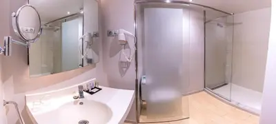 a white bathroom with a shower and a sink at Hotel Madanis in Barcelona