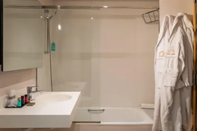 a white bathroom with a sink and a shower at Hotel Madanis in Barcelona