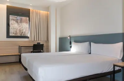 a bedroom with a large white bed and a table at Hotel Sant Pau in Barcelona