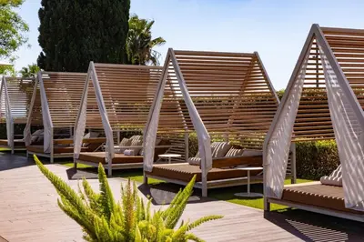 a row of swinging chairs in a garden at Hotel Miramar Barcelona GL - Preferred Hotels & Resorts - Newly Renovated in Barcelona