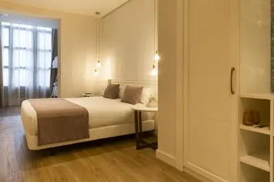 a bedroom with a bed and a table and a window at ICON Bcn in Barcelona