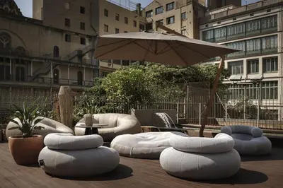 a group of bean bags and an umbrella on a patio at ICON Bcn in Barcelona