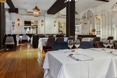 a dining room with white tables and chairs with glasses at Hotel Market in Barcelona