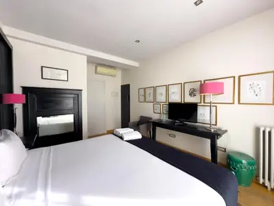 a bedroom with a large white bed and a desk at Hotel Market in Barcelona