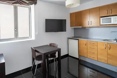 a kitchen with a small table and a microwave at Hesperia Fira in Hospitalet de Llobregat