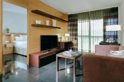 a living room with a couch and a television and a bed at Hesperia Fira in Hospitalet de Llobregat