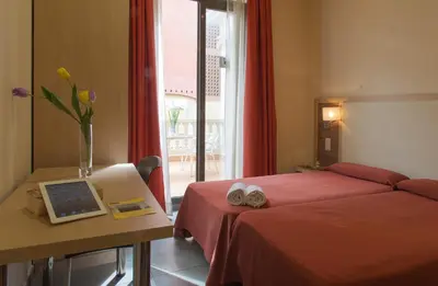a bedroom with a bed and a table with a laptop at Residència Erasmus Gracia in Barcelona
