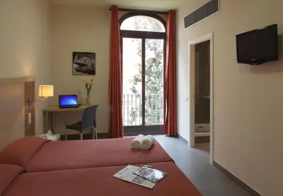 a hotel room with a red bed and a window at Residència Erasmus Gracia in Barcelona