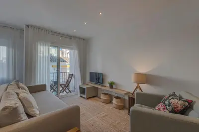 a living room with a couch and a television at Mare Nostrum: En el corazón de Sitges in Sitges