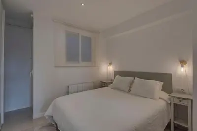 a bedroom with a white bed and a window at Mare Nostrum: En el corazón de Sitges in Sitges
