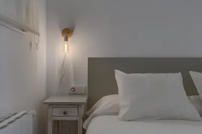 a bedroom with a bed with a white pillow and a lamp at Mare Nostrum: En el corazón de Sitges in Sitges
