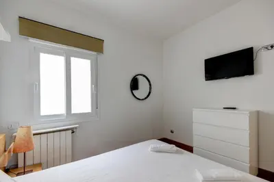 a white bedroom with a bed and a window at Barcelona Beach Vibes in Sant Adria de Besos