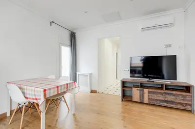 a living room with a table and a flat screen tv at Barcelona Beach Vibes in Sant Adria de Besos