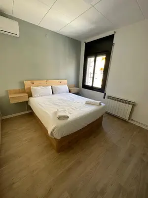 a bedroom with a large bed with a wooden floor at Barcelona Beach Vibes in Sant Adria de Besos