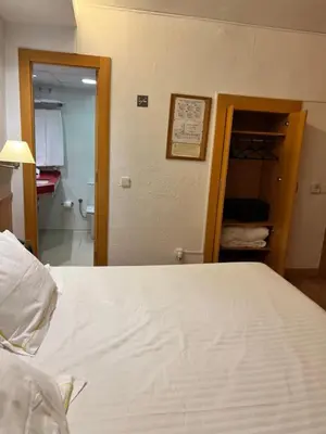 a bedroom with a white bed and a bathroom at Platjador in Sitges