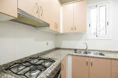 a kitchen with a stove top oven next to a sink at Consell Cent apartment I 3 dormitorios Eixample in Barcelona