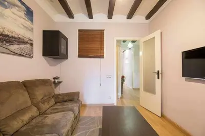 a living room with a couch and a flat screen tv at Consell Cent apartment I 3 dormitorios Eixample in Barcelona