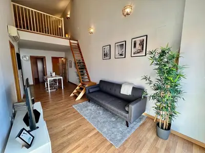 a living room with a couch and a staircase at Apartamento espacioso y familiar in Terrassa
