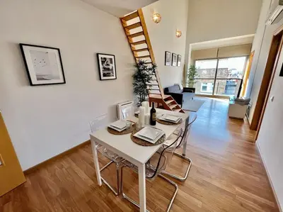 a dining room and living room with a table and chairs at Apartamento espacioso y familiar in Terrassa