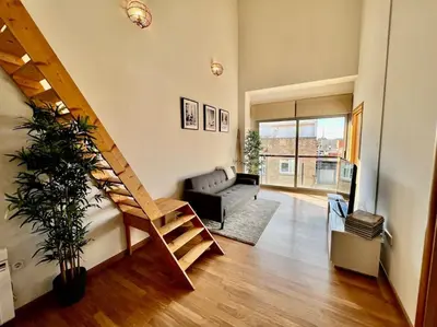 a living room with a staircase and a couch at Apartamento espacioso y familiar in Terrassa