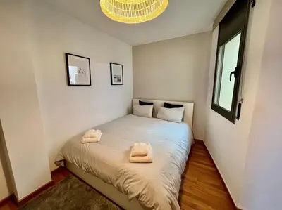 a bedroom with a bed with two towels on it at Apartamento espacioso y familiar in Terrassa
