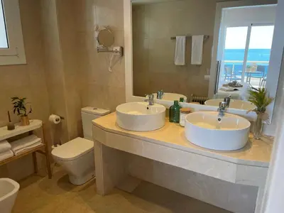 a bathroom with two sinks and a toilet at Mediterraneo Sitges in Sitges